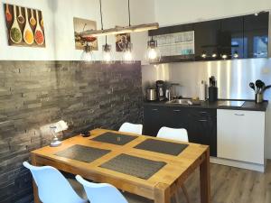 ヴェターにあるModerne Wohlfühloase zentral in Seenähe - Pillow menu, 2 Stk 55" Smart TVs, NETFLIX, DisneyPlus uvmのキッチン(木製テーブル、白い椅子付)