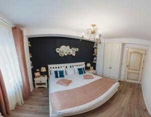 a bedroom with a large bed with blue pillows at La Contessa Apartament in Tîrgu Neamţ