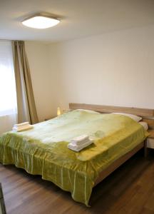 a bedroom with a green bed with two towels on it at Ferienwohnung Waldvogel in Immenstaad am Bodensee