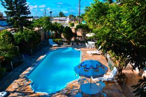 uma vista sobre uma piscina com cadeiras e um guarda-sol em Pousada Italianíssima em Arroio do Silva