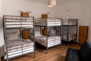 three bunk beds in a room with a couch at OceanOasis in Olhão