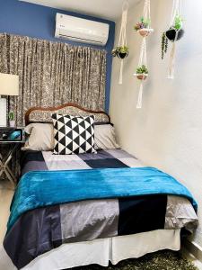 um quarto com uma cama com uma parede azul em Isla Verde By The Beach Guest House em San Juan