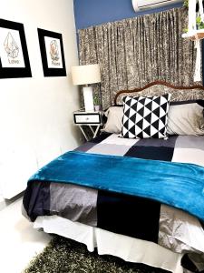 um quarto com uma cama com um cobertor azul em Isla Verde By The Beach Guest House em San Juan