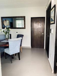 a dining room with a table and a wooden door at Isla Verde By The Beach Guest House in San Juan