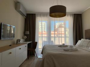 a bedroom with a bed and a large window at Central Point by Zoom Apartments in Bratislava