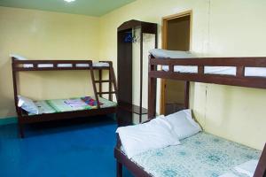 een kamer met 3 stapelbedden en een blauwe vloer bij Enchanted River Rock Island Resort in Hinatuan