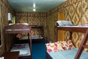 a room with three bunk beds and a door at Enchanted River Rock Island Resort in Hinatuan