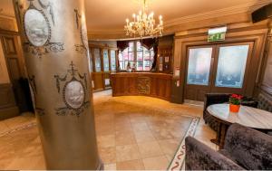 a large lobby with a table and a chandelier at Benedicts Hotel in Belfast +32 photos