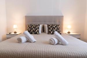a bedroom with a bed with white pillows and two lamps at OceanOasis in Olhão