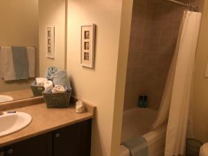 La salle de bains est pourvue d'un lavabo, d'une douche et d'une baignoire. dans l'établissement Willow Pond Satellite B&B, à Port Perry