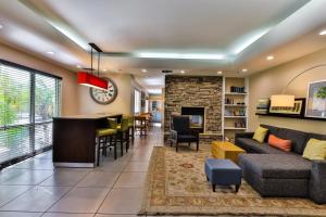 a living room with a couch and a bar at Wingate by Wyndham Chandler Phoenix in Chandler