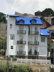 a white house with blue solar panels on it at Regal Rose Luxury Holiday Apartments in Nuwara Eliya