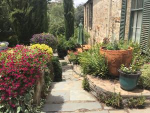 a garden with flowers and plants in front of a building at The OldDevonshire House in Mintaro