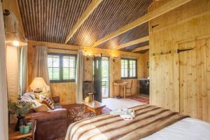 - une chambre avec un lit et un canapé dans l'établissement Off-Grid Relaxing Getaway at The Captain's Rest, à Clachan of Campsie