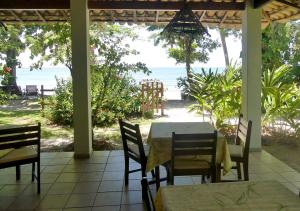 una mesa y sillas en un porche con vistas a la playa en Pousada Tassimirim, en Isla de Boipeba