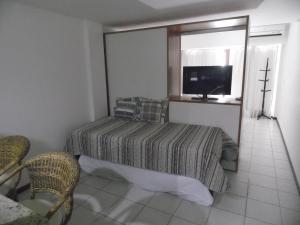 a bedroom with a bed and a tv in it at Sonia Flats Pipa's Bay - Flat 121 in Pipa