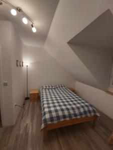 um quarto com uma cama xadrez num sótão em Issy View House em Senovo