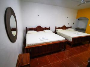 two beds in a room with a mirror at Casa CheJum Bacalar in Bacalar