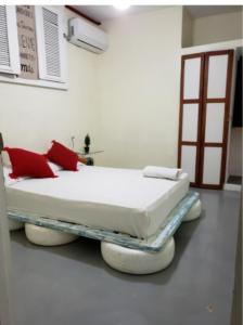 a hospital room with a bed with red pillows at Recycled house in Santo Domingo