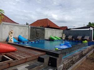 a swimming pool with chairs and a swimming poolitures at Devadav Hostel (Bunk Bed) Nusa Lembongan in Nusa Lembongan