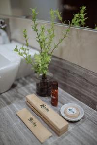 a bathroom counter with two towels and a vase with a plant at Rovira Suites in Dumaguete
