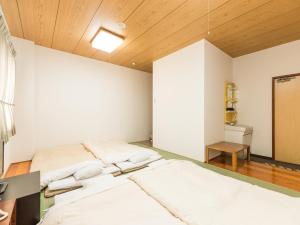 two beds in a room with wooden ceilings at Hotel Isesaki East in Isesaki