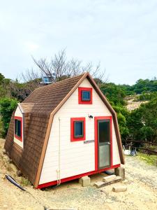 a small house with a brown roof at Grampus Inn Shirahama in Shirahama