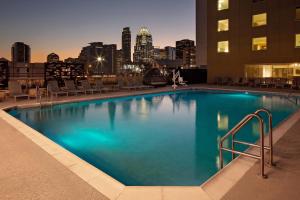 a large swimming pool with a city skyline in the background at Hotel Indigo Austin Downtown, an IHG Hotel in Austin