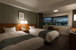 東京にある都市センターホテルのベッド2台と窓が備わるホテルルームです。