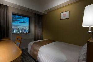 een hotelkamer met een bed en een raam bij Toshi Center Hotel in Tokyo
