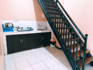 a kitchen with black cabinets and a staircase at Villa Beverly in Lembang
