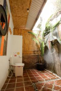 a bathroom with a toilet and a plant in it at Good Karma Yogyakarta in Yogyakarta