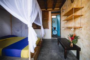帕洛米诺Tiki Hut Hostel的一间卧室，里面有一张床和一张摆着鲜花的桌子