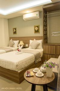 Posteľ alebo postele v izbe v ubytovaní An Hoi Canary Hotel
