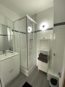 un bagno bianco con doccia e lavandino di La digue 45 Rue des Lais de Mer a Bénerville-sur-Mer