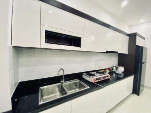 a kitchen with white cabinets and a sink at HOTEL ĐỨC THÀNH 2 in Con Dao