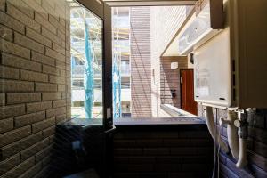 una puerta con una ventana en una pared de ladrillo en Re-Rent Residence 押上, en Tokio
