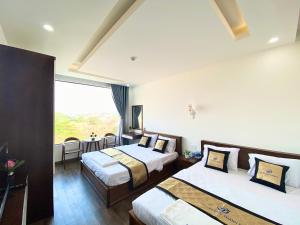 a hotel room with two beds and a large window at HOTEL ĐỨC THÀNH 2 in Con Dao