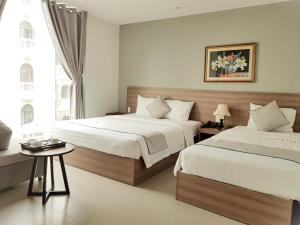 Posteľ alebo postele v izbe v ubytovaní An Hoi Canary Hotel