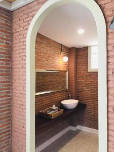 a bathroom with a sink and a brick wall at Baan Karm poo Uthaithani in Ban Nong Nam Khan