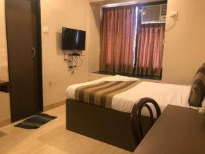een hotelkamer met een bed en een raam bij Lucky Service Apartments in Mumbai