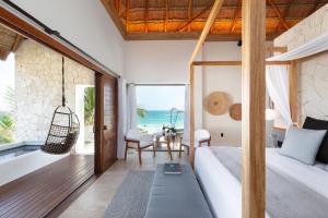 a bedroom with a bed and a view of the ocean at Tago Tulum by G Hotels in Tulum