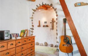 Habitación con tocador de madera y guitarra en Beautiful Home In Thyholm With House A Panoramic View, en Thyholm