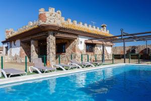 a house with a swimming pool in front of a building at El Castillito in Chiclana de la Frontera