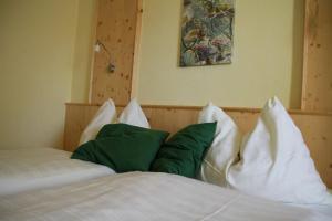 a bedroom with a bed with green and white pillows at Lindenhof- Fam. Forstmayr in Haag