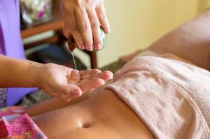 Eine Frau bekommt eine Massage von einer Frau in einem Spa-Training. in der Unterkunft Anahata Resort in Lipa Noi