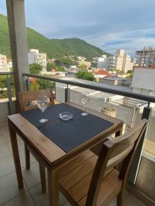 a wooden table with two wine glasses on a balcony at Luxury Appart in Salta