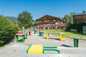 um parque com bancos coloridos em frente a um edifício em Bruggerhof - Camping, Restaurant, Hotel em Kitzbühel