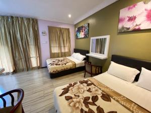 ein Hotelzimmer mit zwei Betten und einem Tisch und Stühlen in der Unterkunft Redang De' Rimba in Pulai Redang