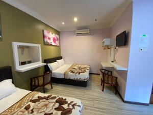 ein Hotelzimmer mit zwei Betten und einem Spiegel in der Unterkunft Redang De' Rimba in Pulai Redang